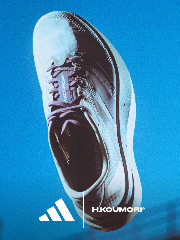 A close-up view of a white and black athletic shoe with the Adidas H.Koumori logo prominently displayed against a vibrant blue background.