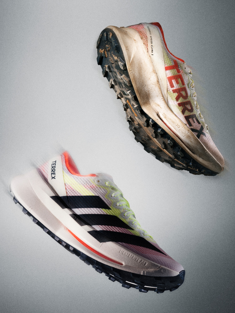 Two pairs of worn and dirty runners, one in a light pink and white colour scheme and the other in a black, white, and orange colour scheme, are displayed against a plain grey background.