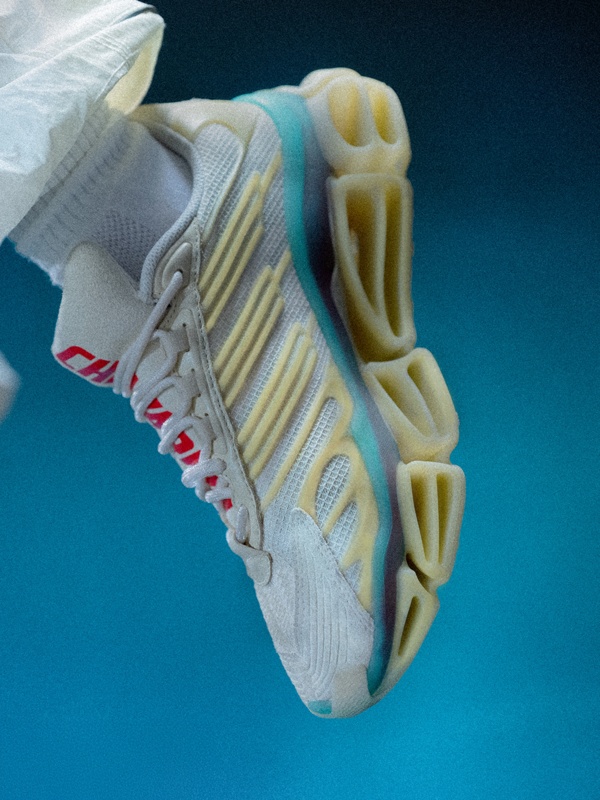 A close-up view of a colorful, athletic shoe with a distinctive sole design against a vibrant blue background.