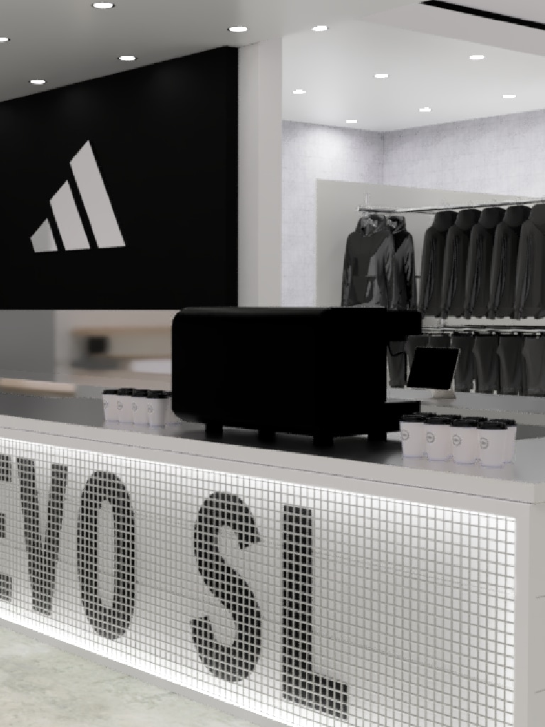 A black and white image of a retail store interior, featuring a counter with the word "VOSL" displayed prominently, and a large Adidas logo visible on the wall in the background.