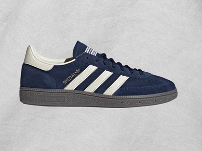A pair of navy blue and white Adidas Samba sneakers against a light gray background.