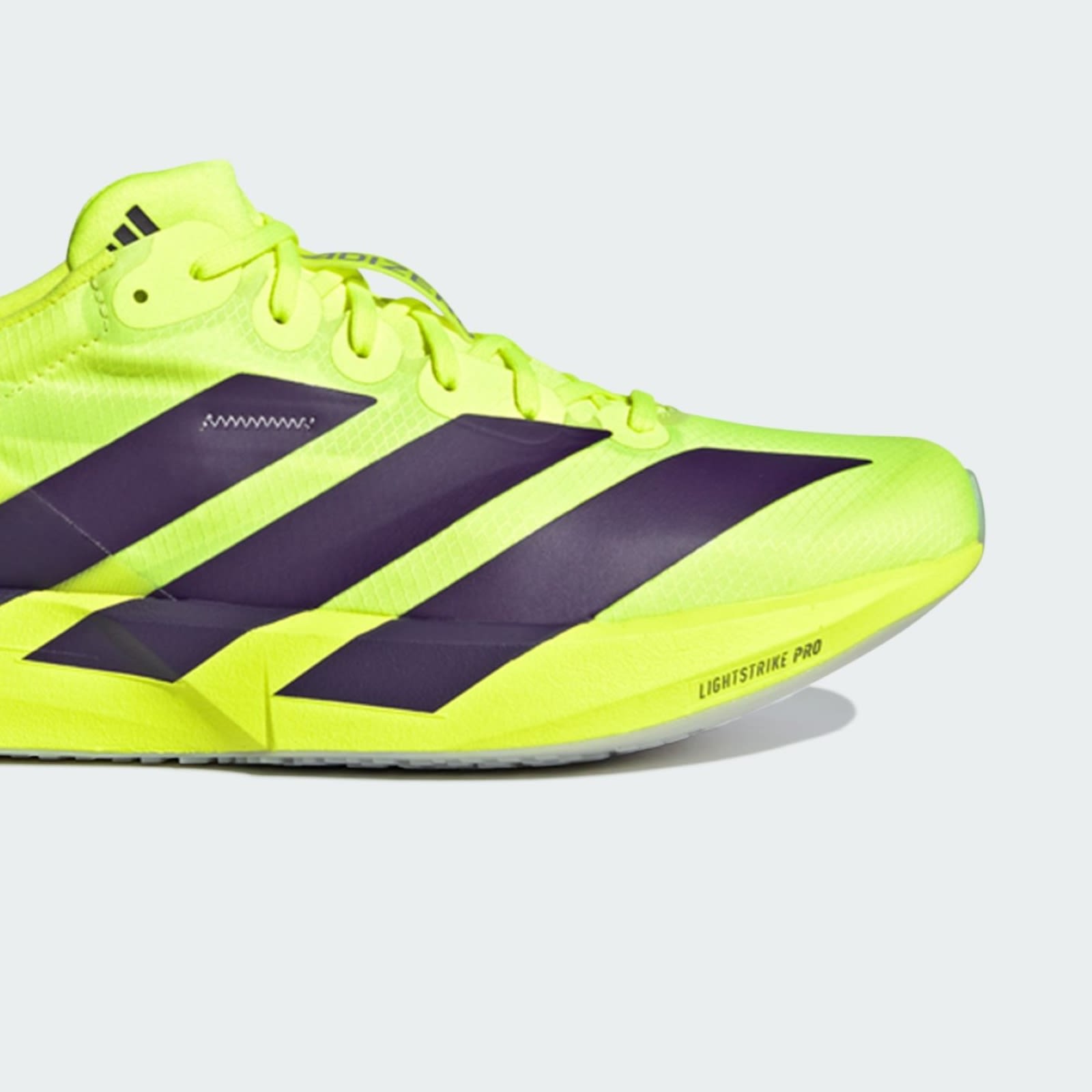 A bright neon yellow and black athletic shoe with distinctive Adidas branding and design elements.