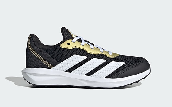 A pair of black and white athletic shoes with yellow accents, set against a plain white background.
