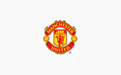 The image depicts the iconic Manchester United football club logo, featuring the club's name and crest in vibrant red, yellow, and green colors against a white background.