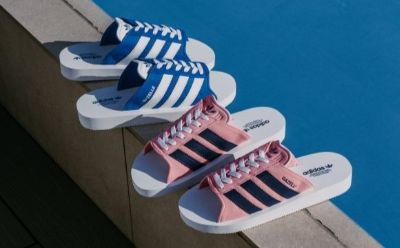 The image shows several pairs of colorful sneakers, including blue and white ones as well as pink and black ones, hanging on a wall against a bright blue background.