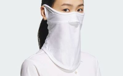 A person wearing a white face mask, with only their eyes visible, against a plain white background.