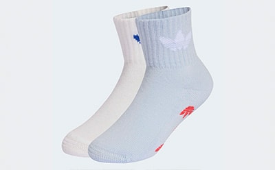 A pair of white athletic socks with blue and red logos on a plain background.