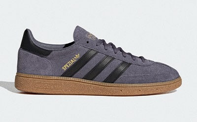 A pair of gray and black Adidas Spezial sneakers with a gum sole, resting on a plain white background.