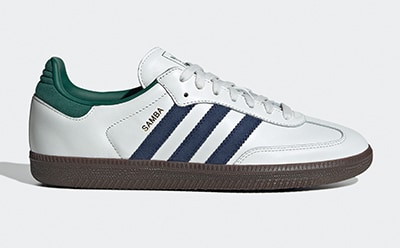 A pair of white, navy, and green Adidas Samba sneakers on a plain white background.