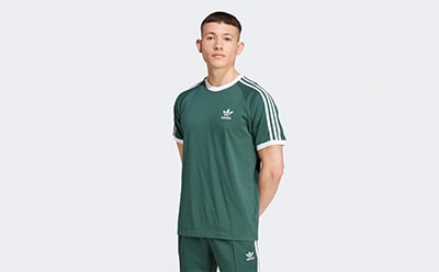 A young man wearing a green and white striped athletic jersey stands against a plain white background.