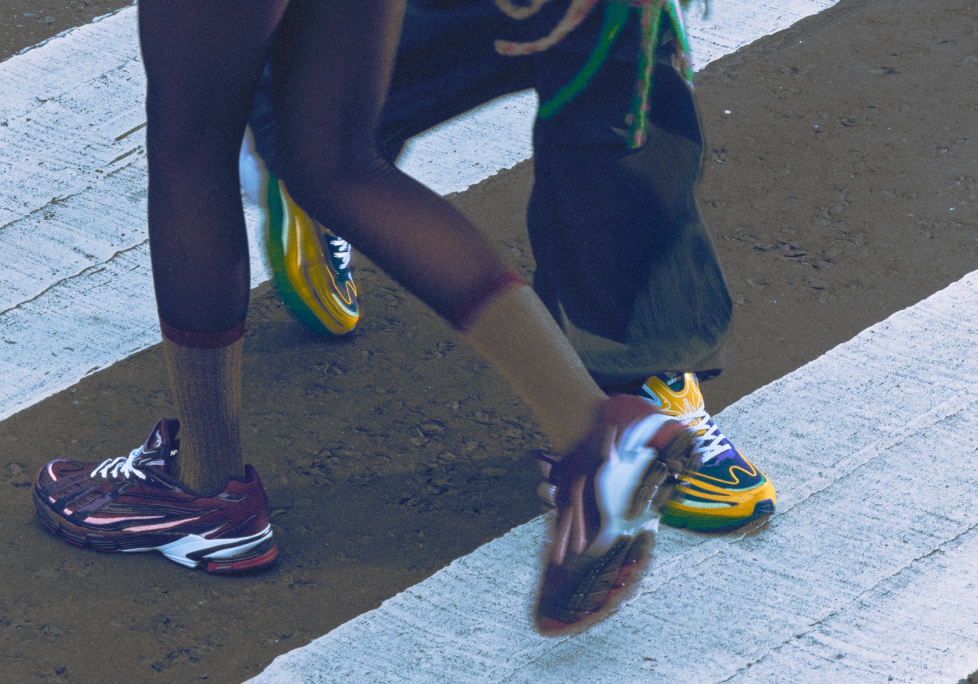 The adidas BAPE Orketro in yellow, green, and blue, plus the pink and purple version, pictured on-foot at a street crossing.
