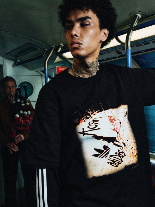 This image depicts a model wearing the adidas Originals x KoRn graphic tee.