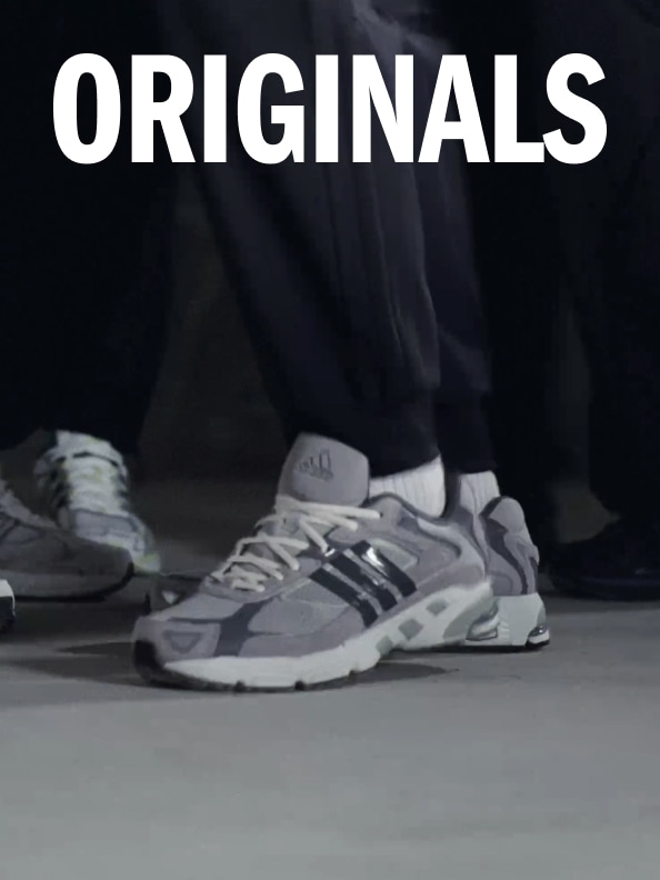 A pair of sneakers from the 2000's Running footwear collection in a dimly lit room with ORIGINALS spelled out at the top of the photo.