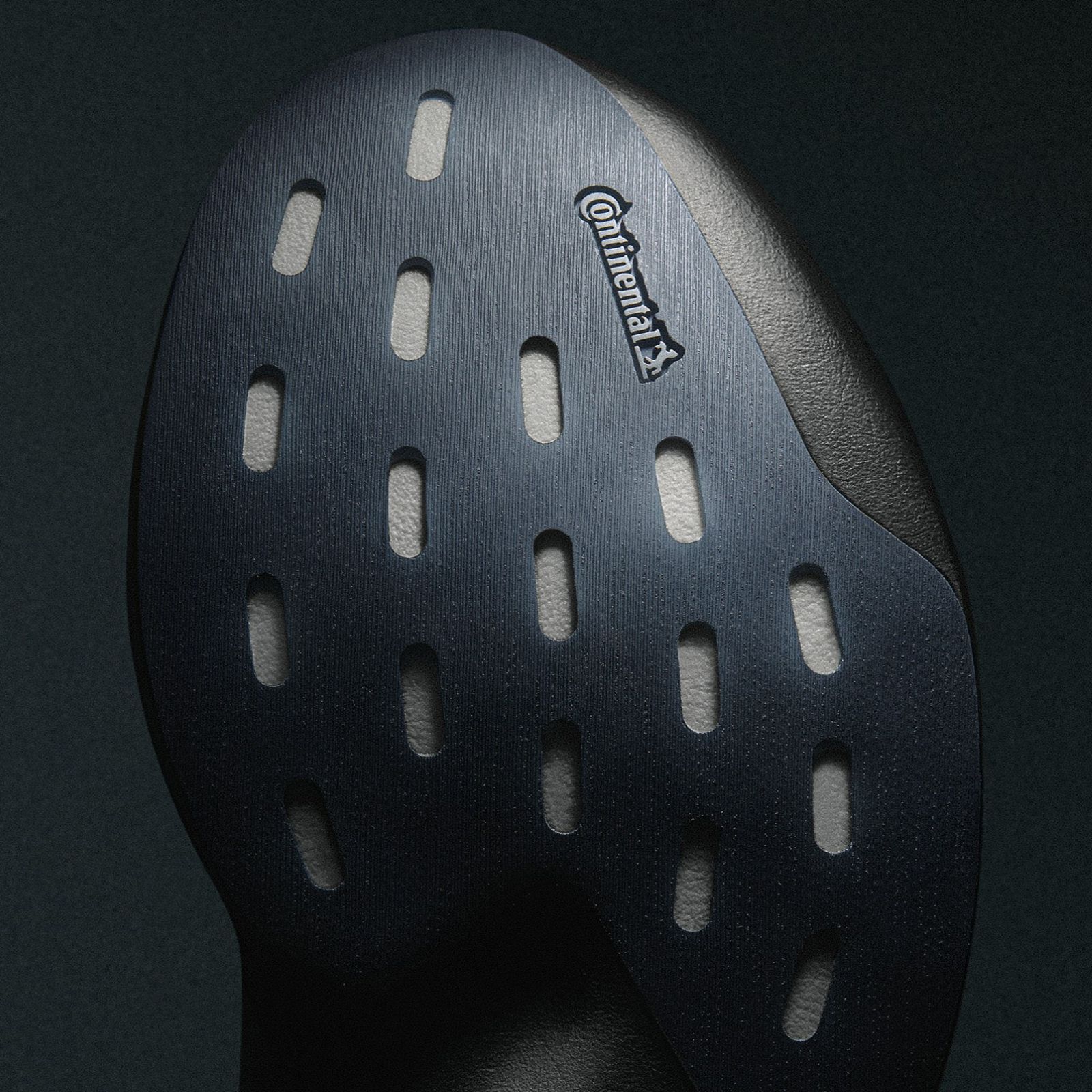 A black, textured surface with a large, perforated object in the center, bearing the Camelbak logo.