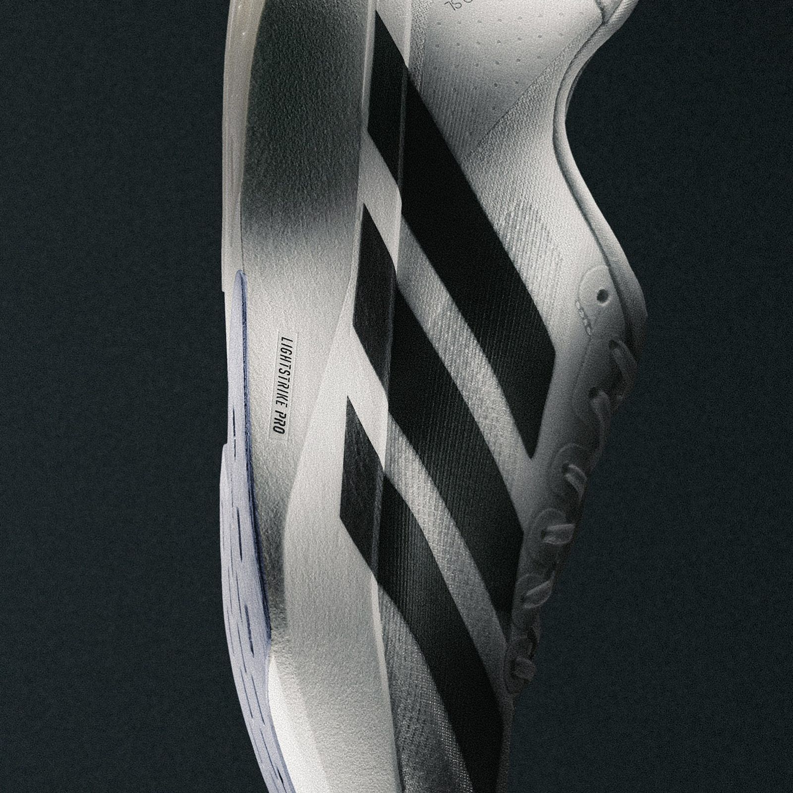 A close-up view of a pair of white and black athletic shoes with distinctive stripes and patterns, set against a dark background.