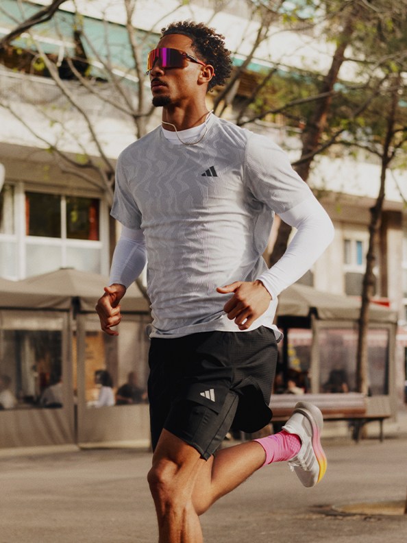 Image of a man running outdoors wearing adidas apparel and Ultraboost 5.