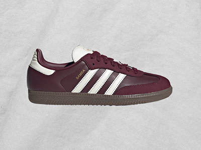 Τα Adidas Samba σε σκούρο γκρι φόντο ξεχωρίζουν με μπορντό και λευκό χρώμα.