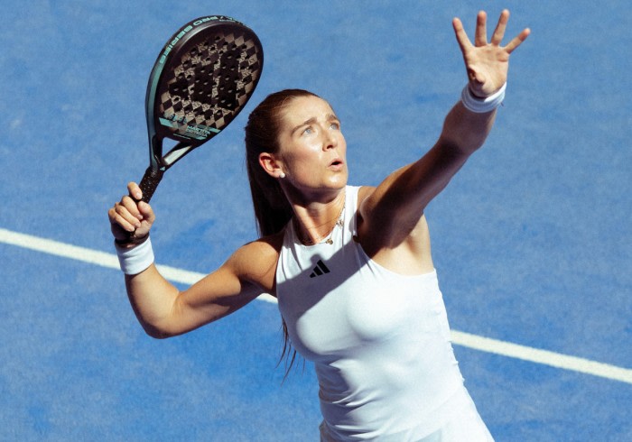 A woman wearing the new adidas padel gear and playing padel.