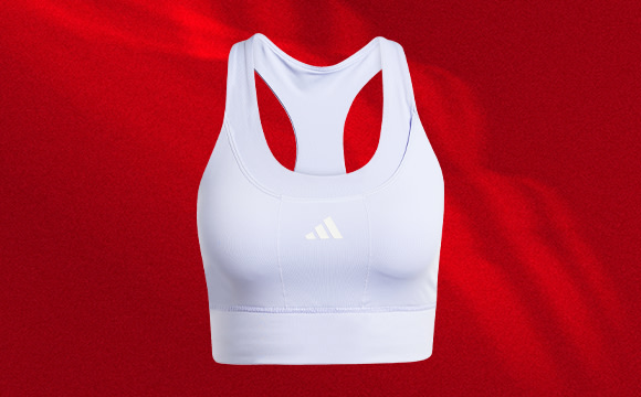 A white sports bra with the Adidas logo against a vibrant red background.