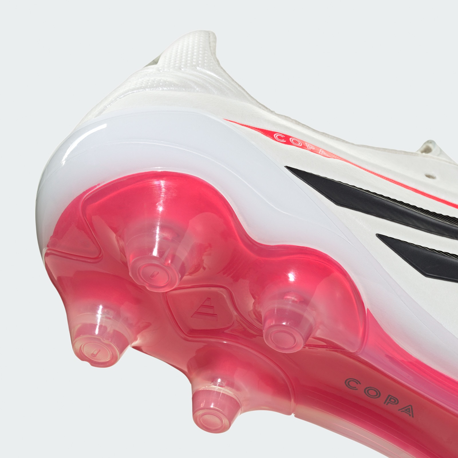A close-up view of a white and red soccer cleat, showcasing its sleek design and prominent branding.