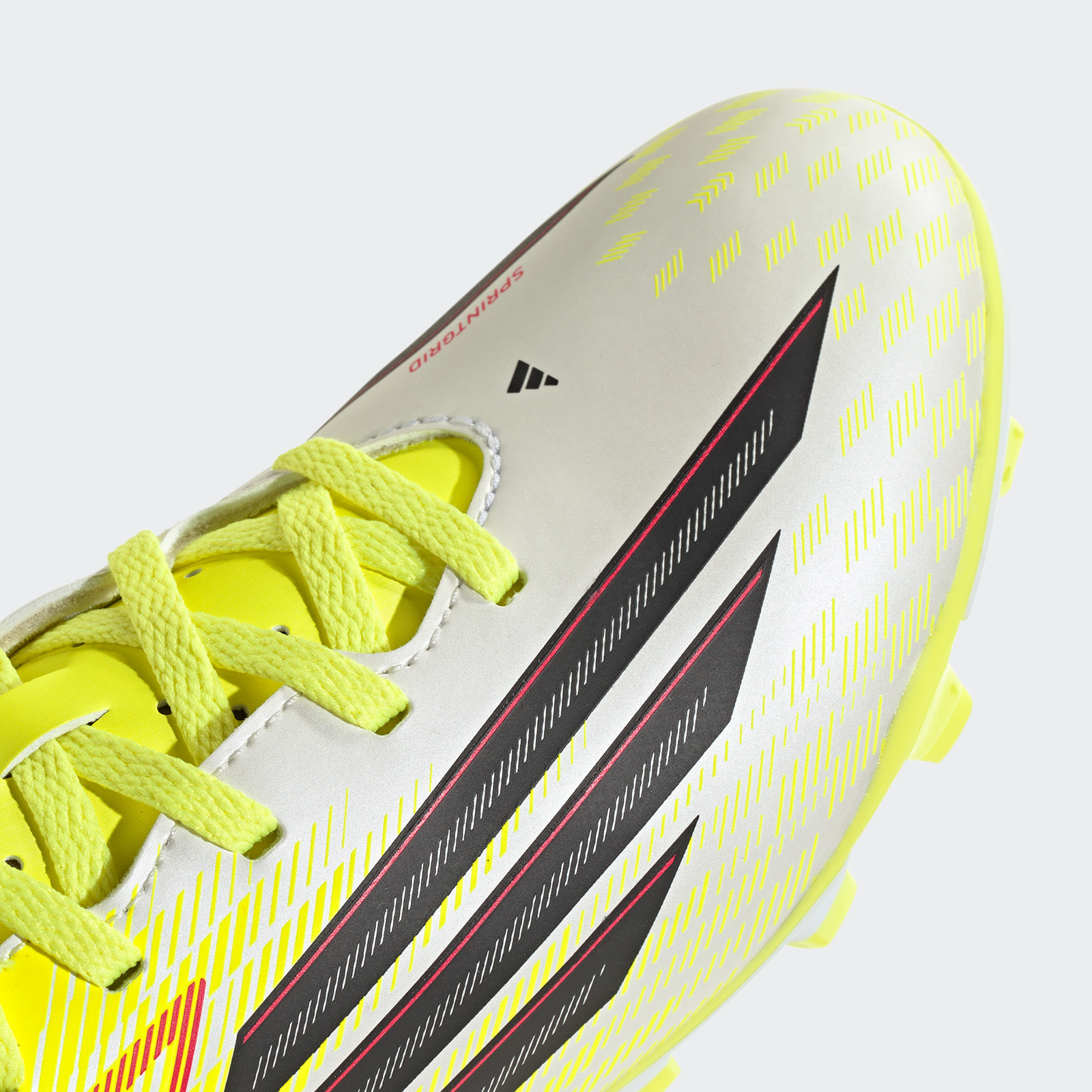 A close-up view of a bright yellow and white athletic shoe with bold black and red stripes, set against a plain white background.
