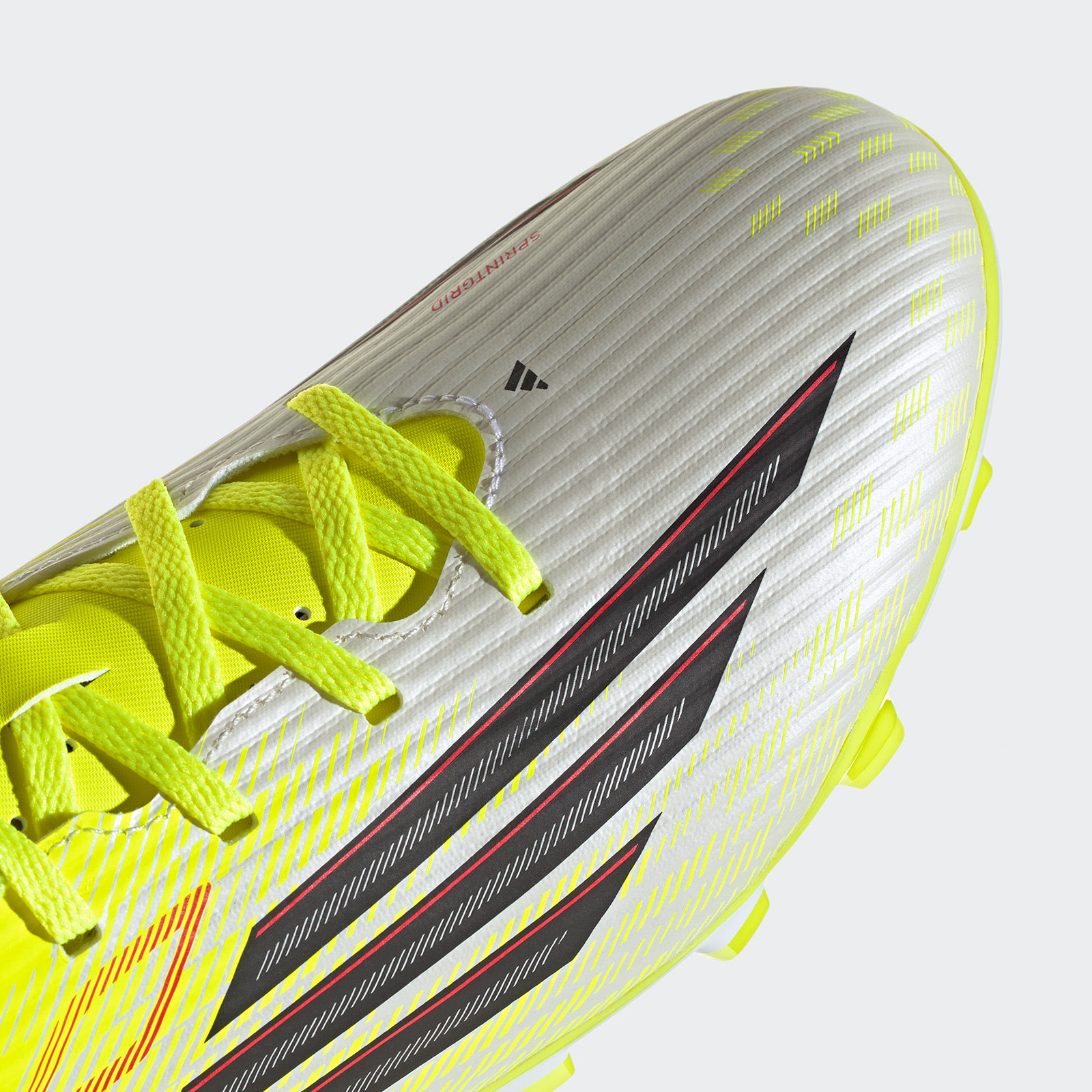 A silver and yellow sports shoe with vibrant laces and a sleek, aerodynamic design against a plain white background.