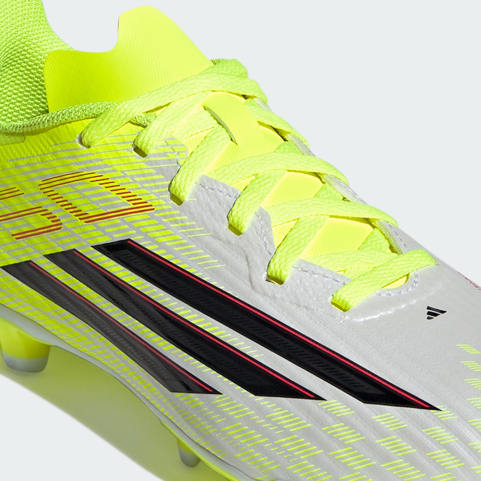 A close-up view of a bright yellow and white athletic shoe with bold black and red stripes, set against a plain white background.