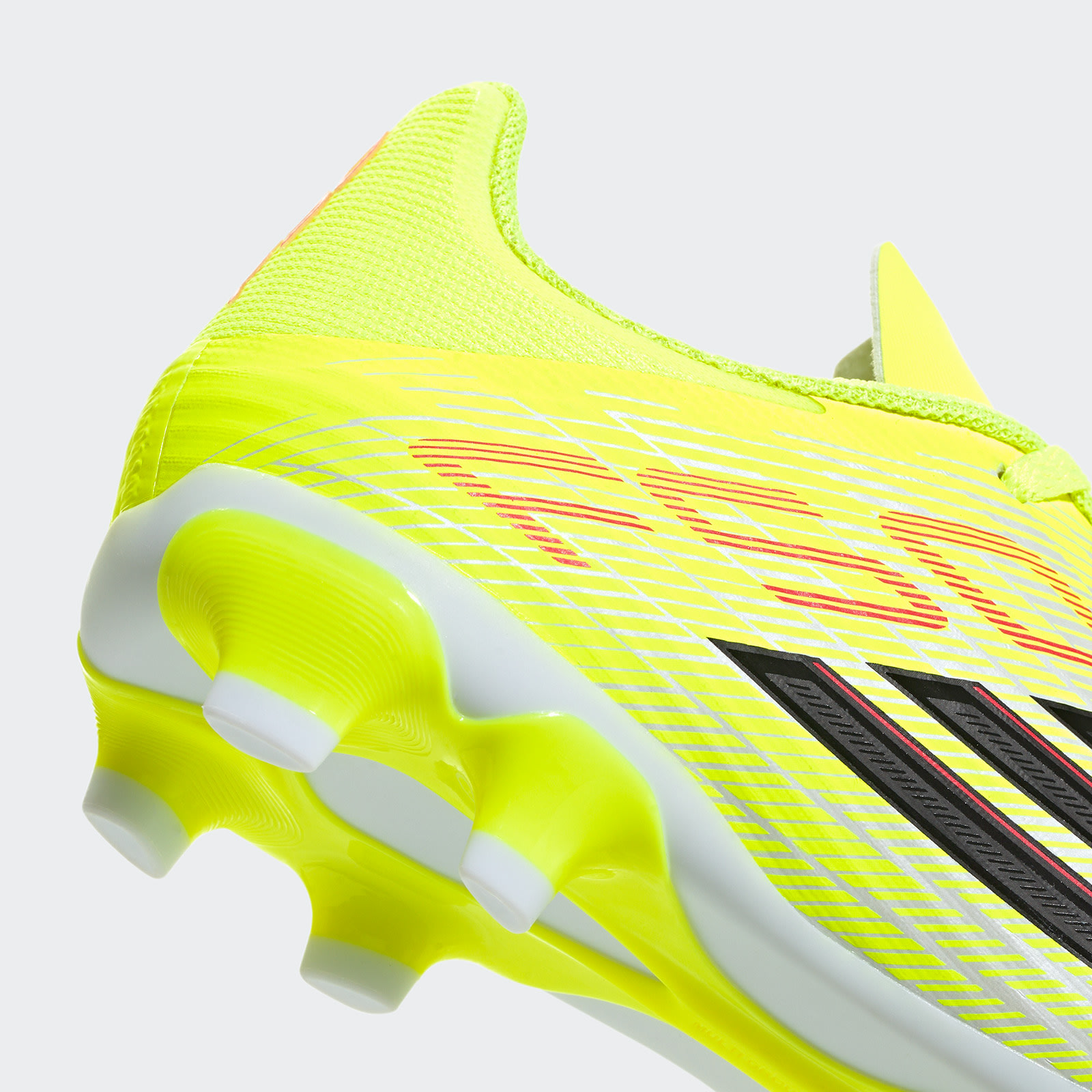 A close-up view of a bright yellow and black soccer cleat with a distinctive wavy pattern on the side.