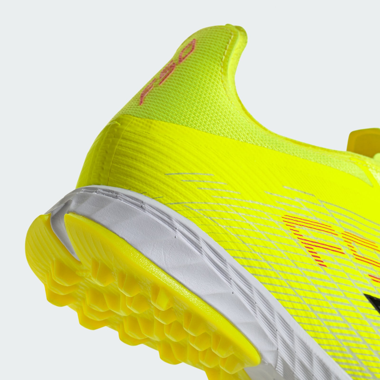 A bright yellow and neon green soccer cleat with a textured upper and a yellow and gray sole, against a plain white background.