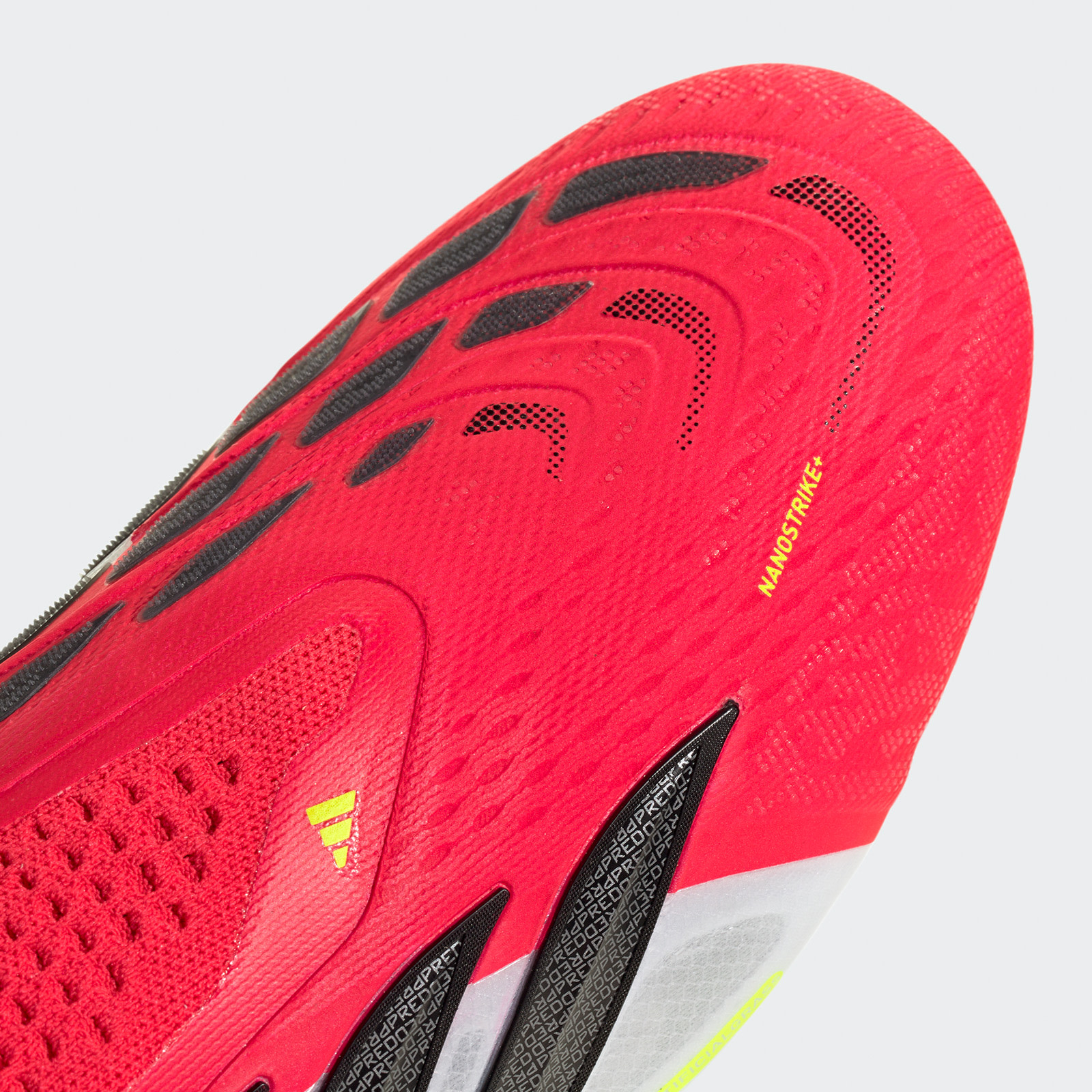 A close-up view of a bright red and black athletic shoe with a textured, mesh-like upper and a prominent logo on the side.