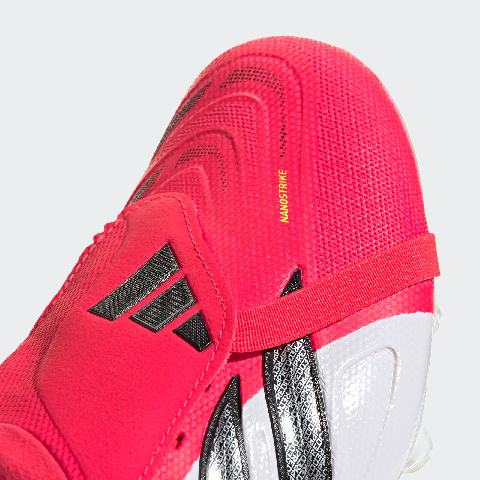 A close-up view of a bright red and white athletic shoe with a textured upper and black accents, set against a plain white background.