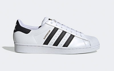 A pair of white and black Adidas Superstar sneakers with the iconic three-stripe design on a plain white background.