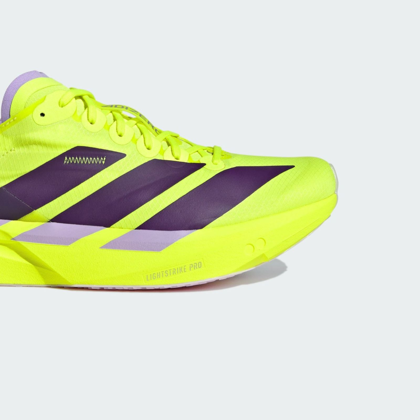 A bright neon yellow and purple athletic shoe with distinctive stripes and a sleek, modern design against a plain background.
