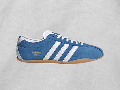 Λευκά και μπλε adidas Tokyo sneakers σε ανοιχτό γκρι φόντο.