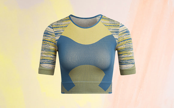 A colorful, abstract sweater or shirt with geometric patterns and shapes in shades of blue, yellow, and green against a soft, pastel-colored background.