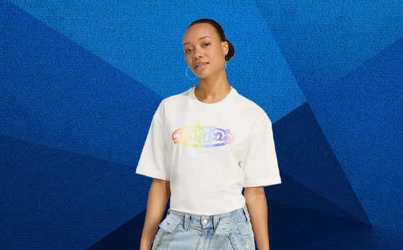 A person wearing a white t-shirt with a colorful graphic design stands in front of a vibrant blue background.