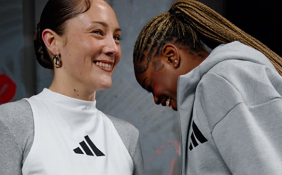 The image shows two people, a woman with a warm smile and a man with dreadlocks, standing close together and appearing to have a friendly interaction.