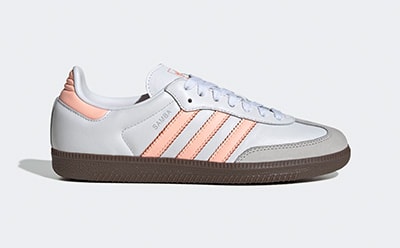 A pair of white, pink, and gray sneakers with a gum sole against a plain background.