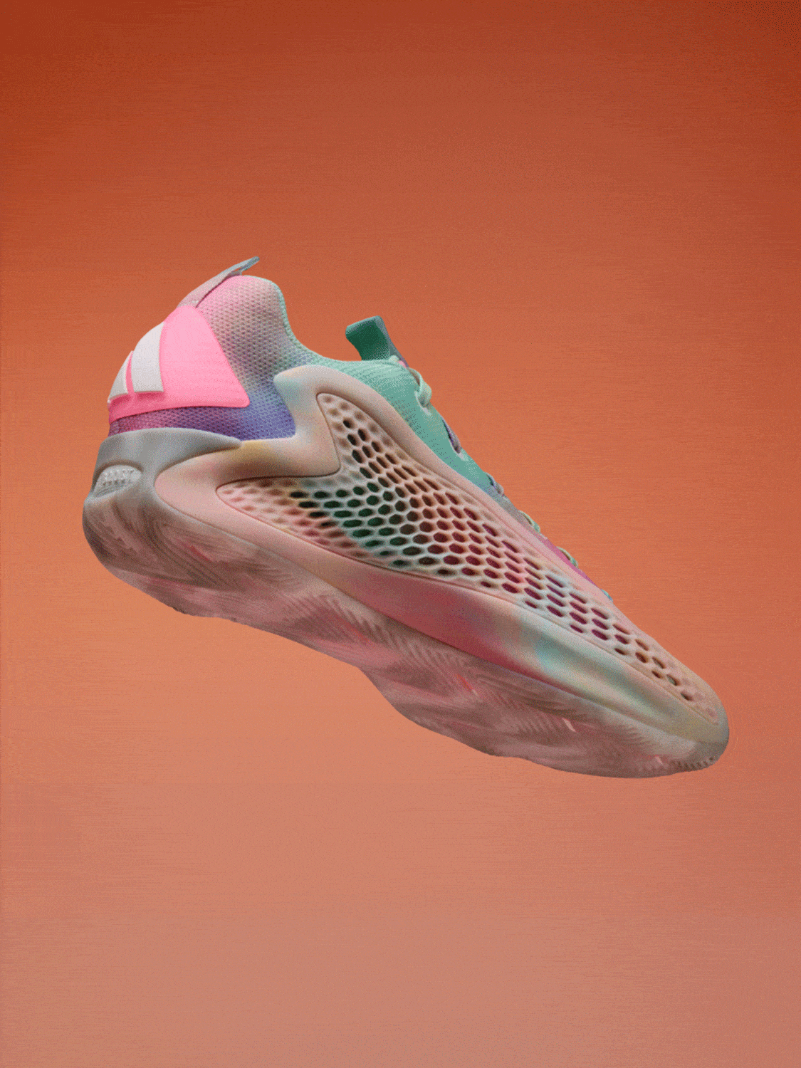 A vibrant, multicolored sneaker with a dynamic, perforated design stands against a warm, orange background.