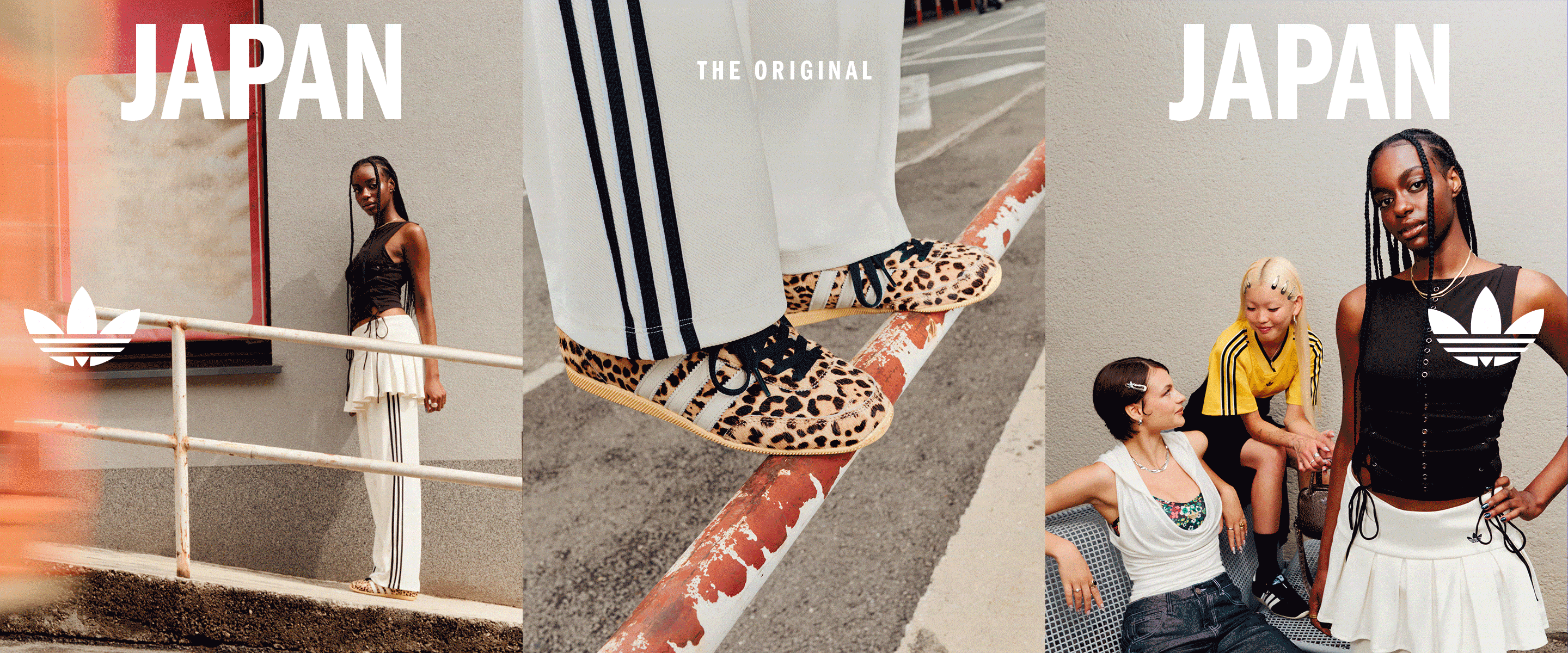 The image features several large posters or advertisements for "Japan" featuring various models or individuals in different poses and outfits, with a railing or barrier visible in the foreground.