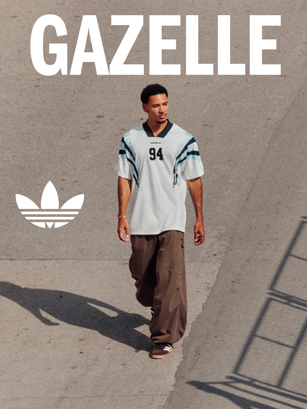 A young man wearing a white sports jersey with the number 94 stands in front of a large "GAZELLE" sign against a plain background.