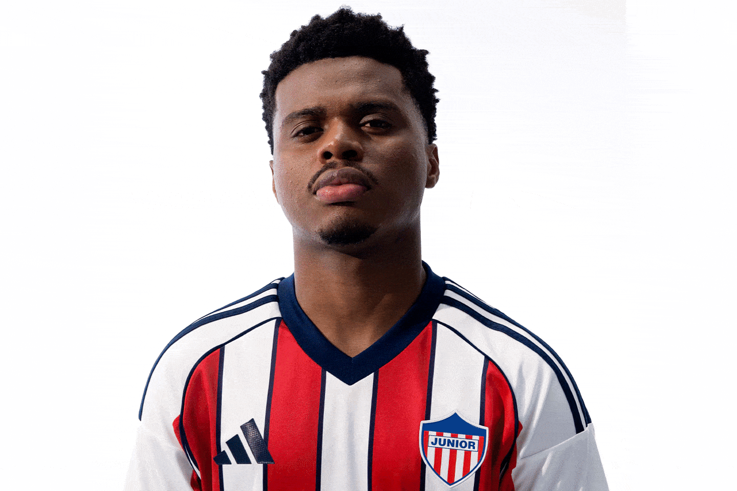 A young man with short dark hair wearing a striped sports jersey stands against a plain white background.