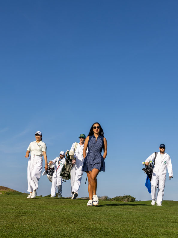Group of golfers walk on course.