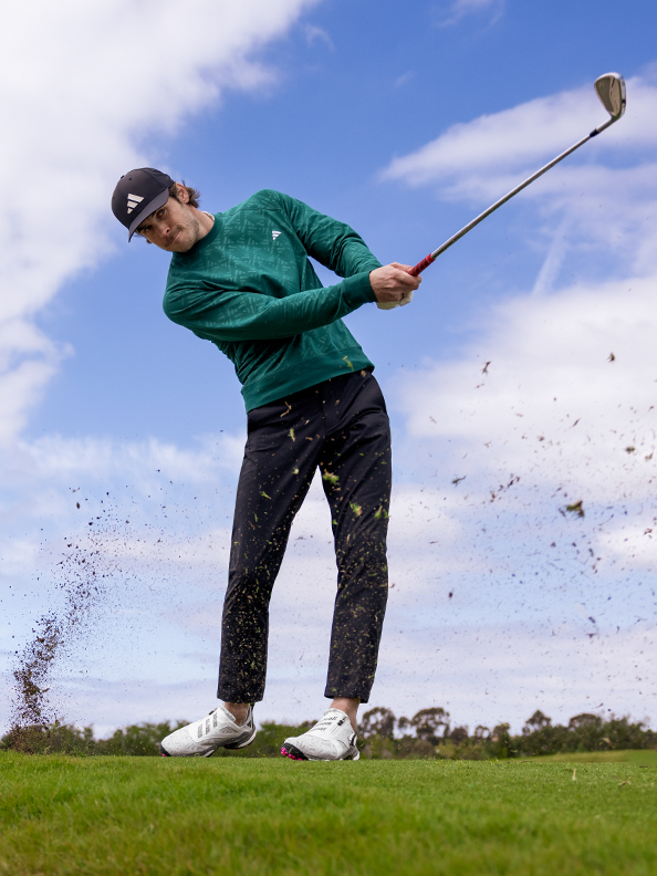 Man golfing in adidas outfit