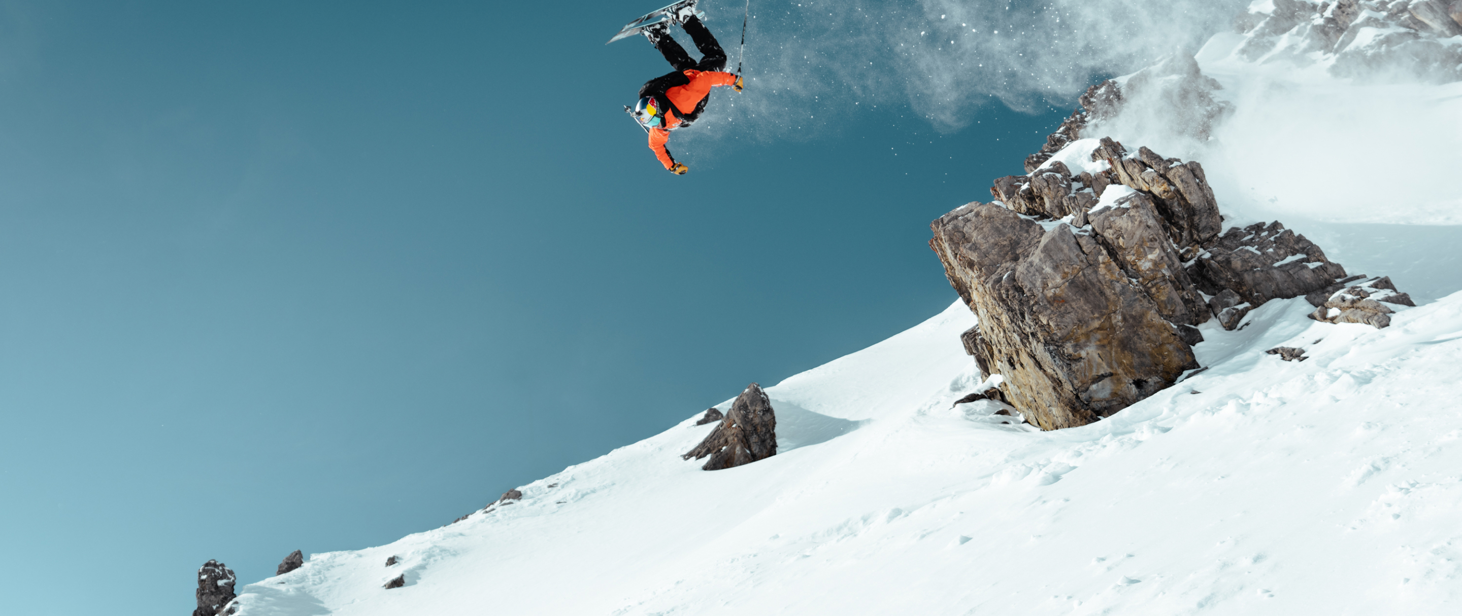 Skier somersaults upside down on the slopes wearing The Terrex Adventure Wardrobe FW24 Collection