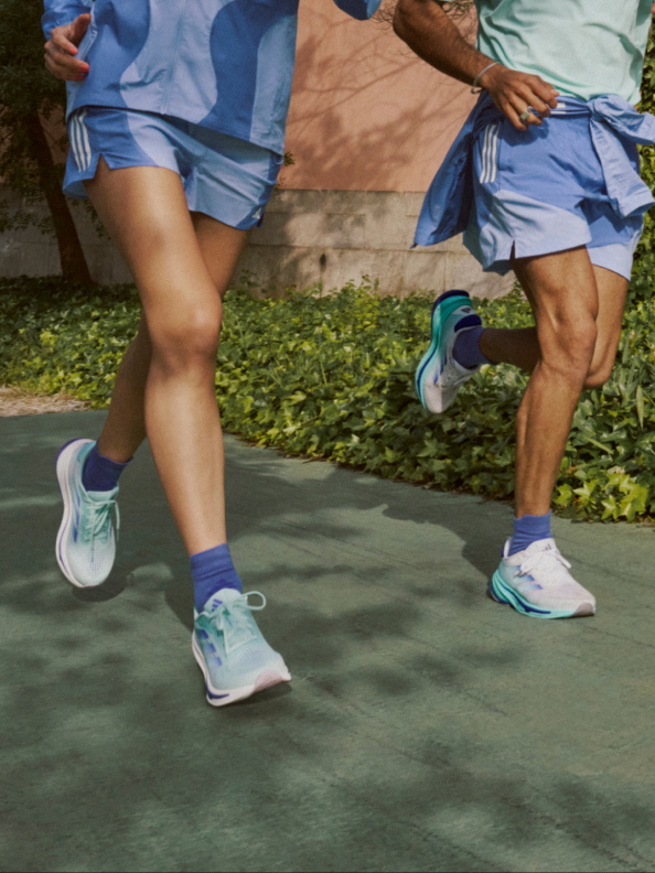 The adidas Supernova running shoes pictured on-foot on an asphalt street.