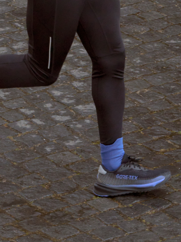 The black and blue Supernova GTX pictured on-foot on a cobblestone street.