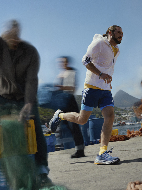 Image of a man running outdoors wearing adidas.