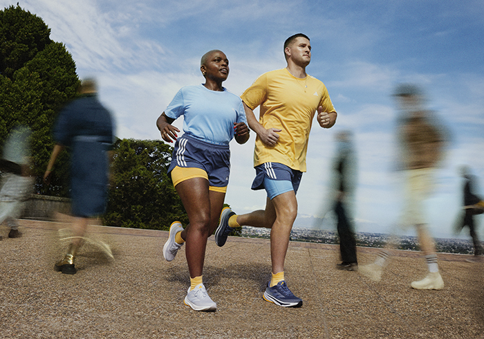 Image of two people running outdoors wearing adidas running gear.