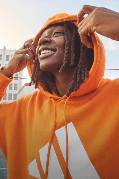 WNBA star Erica Wheeler smiles as she pulls her orange adidas hoody away from her face.